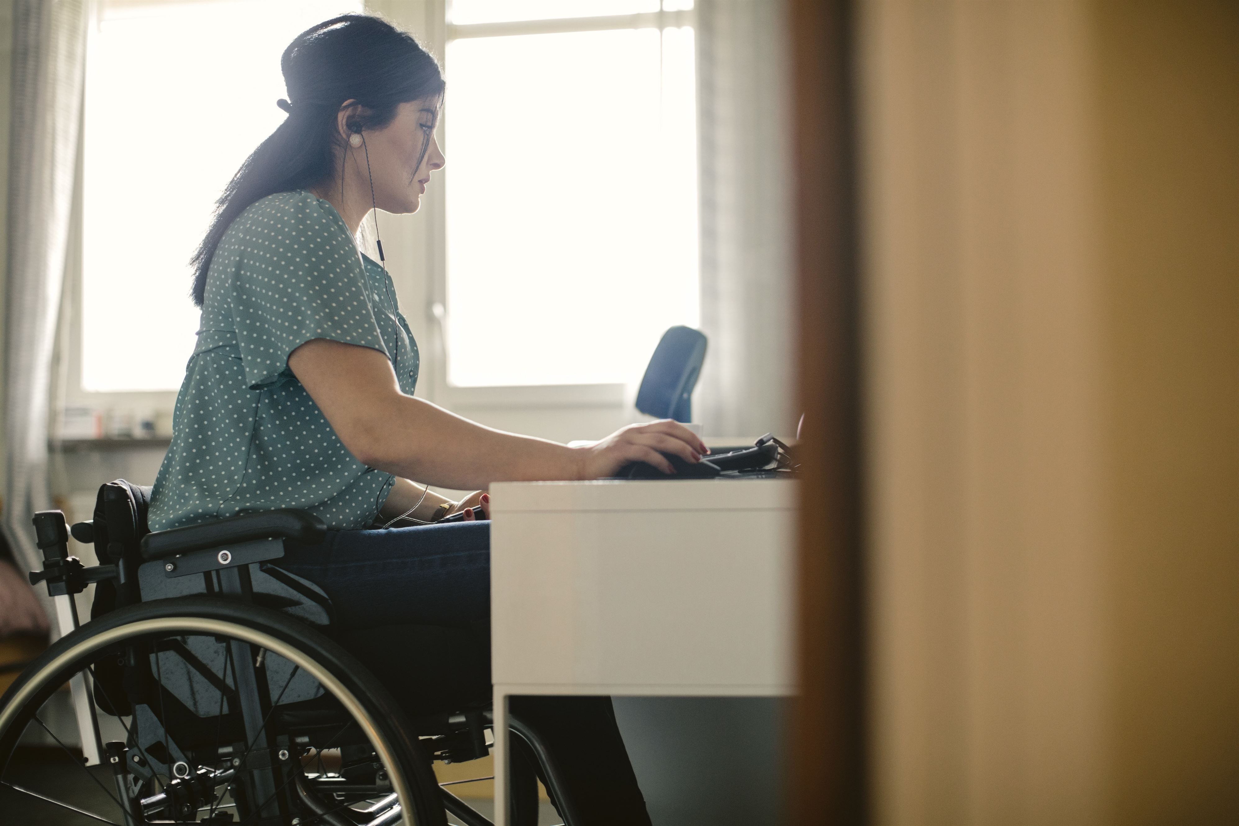 Woman in wheelchair works on computer