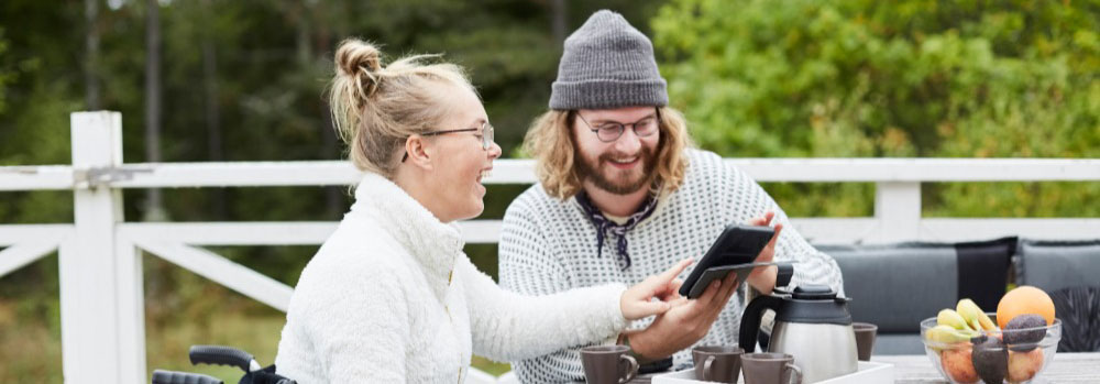 A person with CP looks at a tablet with someone else